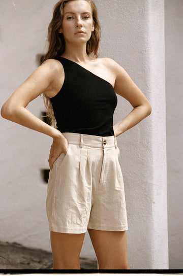 Beige cotton high-waisted shorts with one-shoulder black tank top